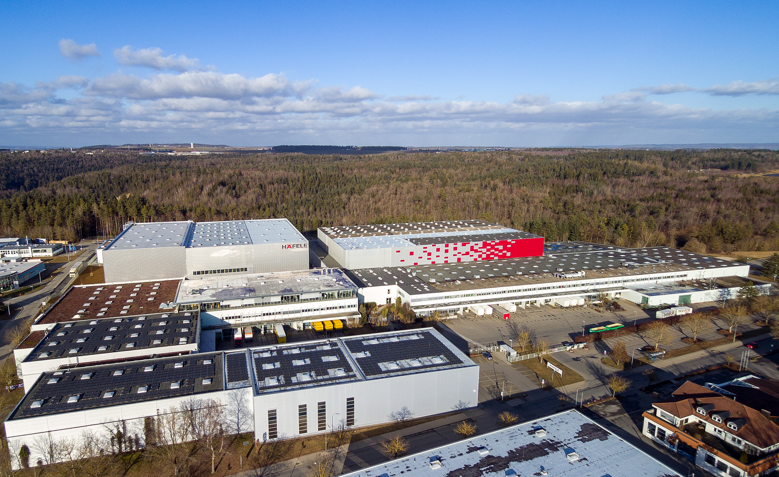 Häfeles logistikcenter på Wolfsberg i Nagold vokser fortsat. Med det fjerde, fuldautomatiske højlager (på billedet bagest til venstre) udvider beslagspecialisten sin kapacitet med 15.000 Europa-pallepladser.